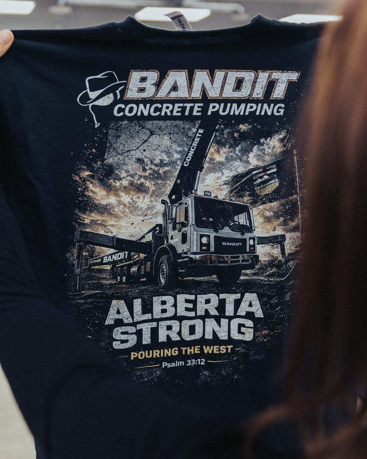 Black Bandit Concrete Pumping crew tee held up to show the back print