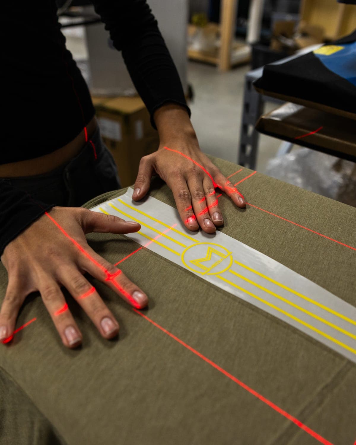 Positioning a DTF transfer on an olive tee under the press lasers