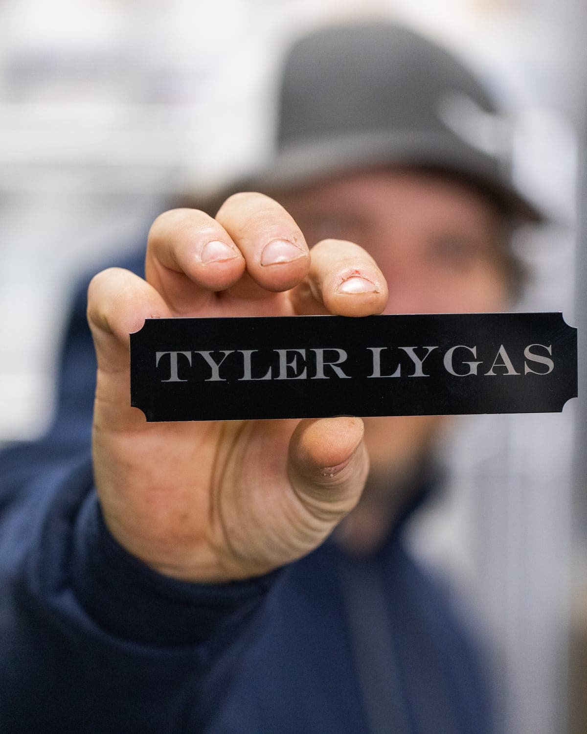 Engraved Tyler Lygas name badge held up to the camera