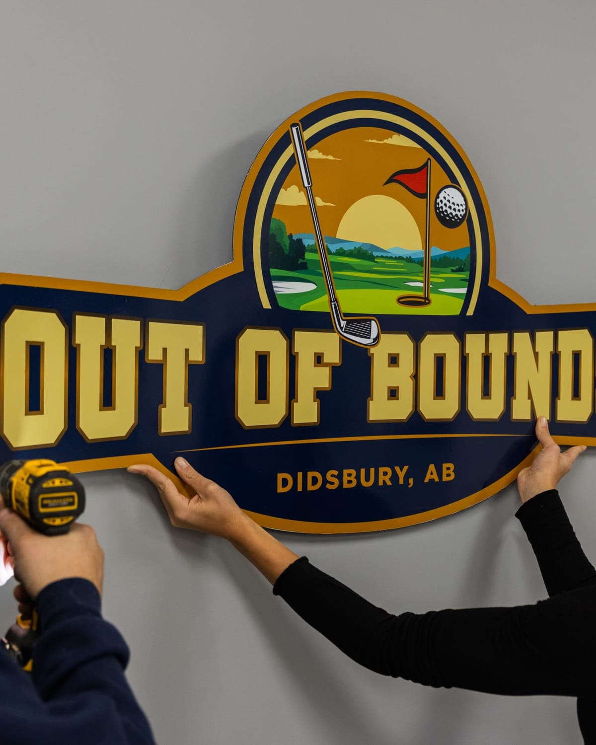 Installing the Out of Bounds dimensional sign on a wall