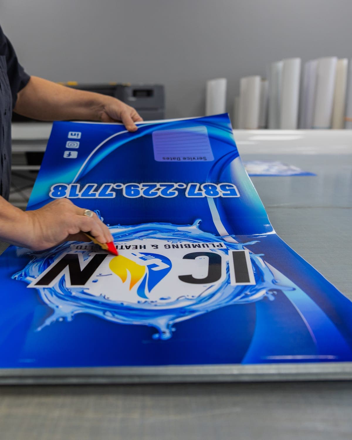 Laying out a large printed vinyl panel on the shop table